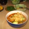 Vegan/Vegetarian Tortilla Soup in blue bowl with toppings in bowls behind it
