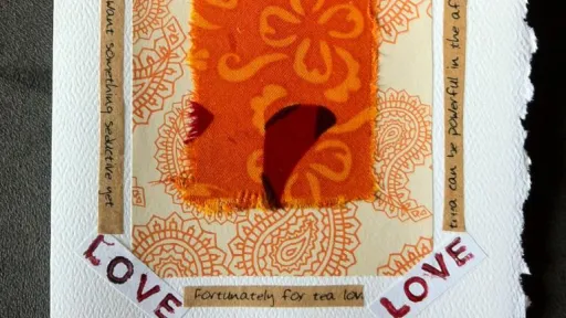Handmade card with orange fabric rectangle, paisley background, and red "LOVE" corners.