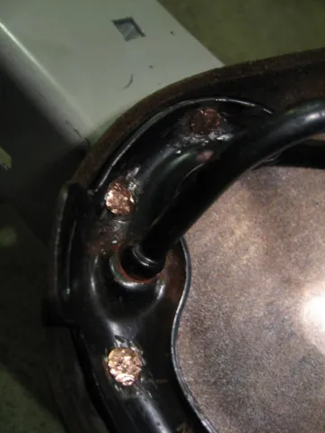 A person in a kitchen proudly holds up a large, golden-brown fried turkey on a platter.