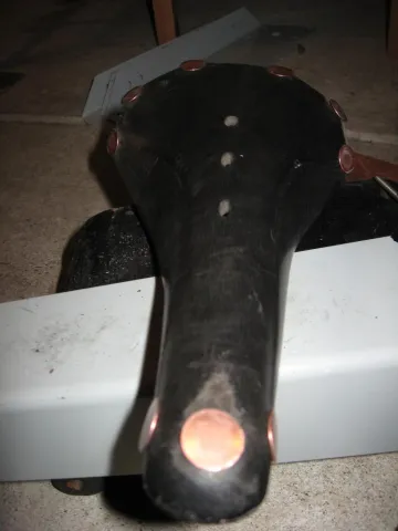 A person's hand with red painted fingernails holds a red credit card with the Walmart logo, tapping it onto a black point-of-sale terminal. The terminal screen is visible, and the background is a blurred view of a store.