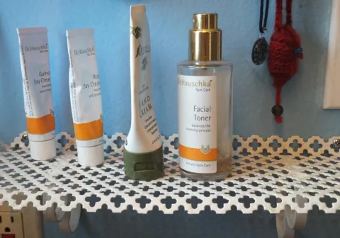 Dr. Hauschka skincare products, including facial toner, on a white decorative shelf.