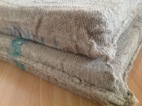 Two stacked burlap sacks with faint blue markings.