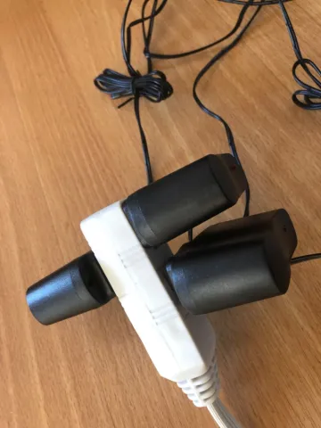 White power strip with multiple black plugs on a wooden surface.